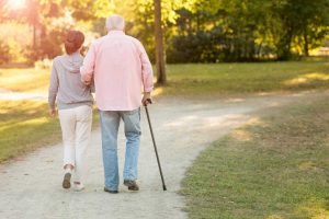 senior with cane walking with young woman